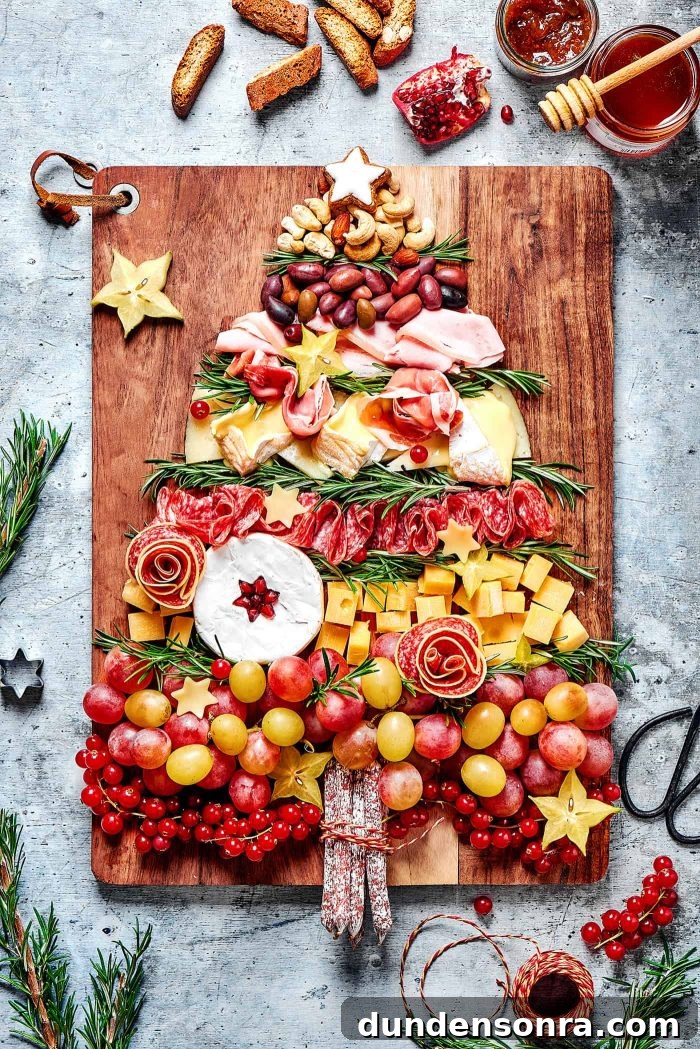 Christmas Tree Charcuterie Board Charcuterie board with meats and cheese in the shape of a Christmas tree.