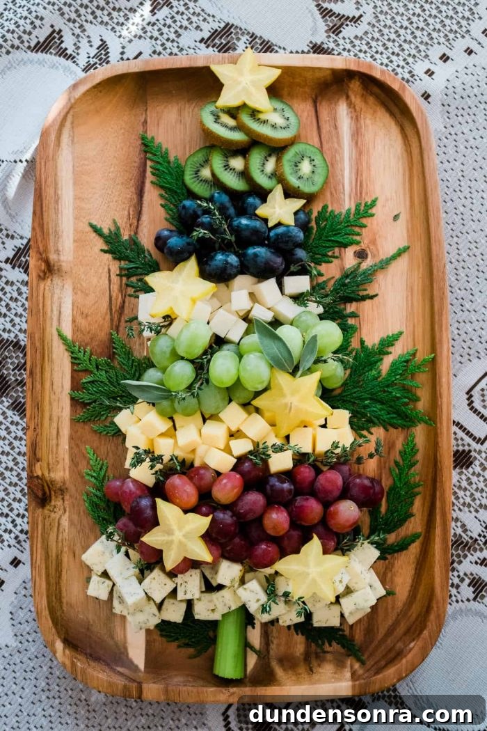 Fruit and Cheese Board Grapes and cheese layered on a wooden board in the shape of a tree.