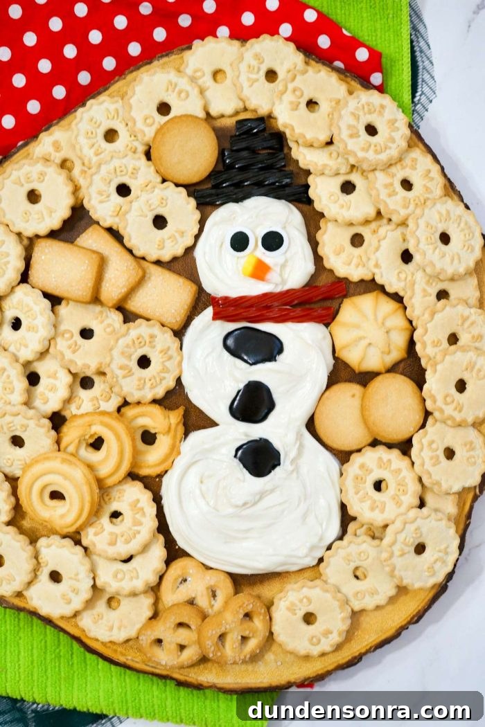 Snowman Dessert Board Frosting in the shape of a snowman surrounded by cookies.