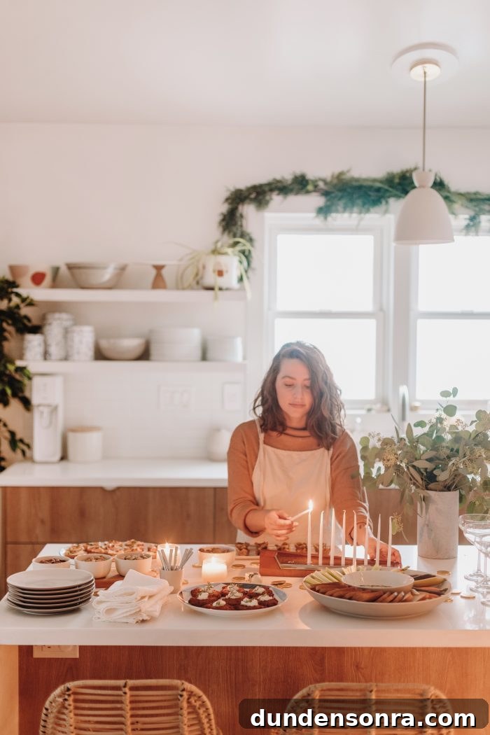 Woman lighting a candle with appetizers on the table next to her. 