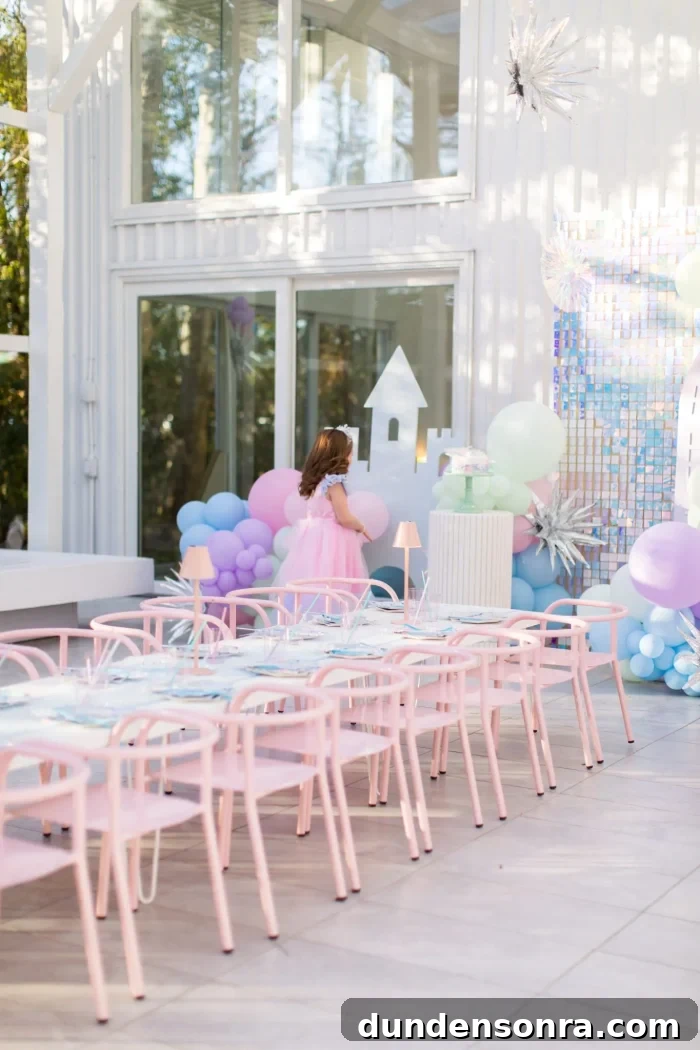 Frozen Winter Party pastel frozen themed birthday party with long kids table and balloons behind it