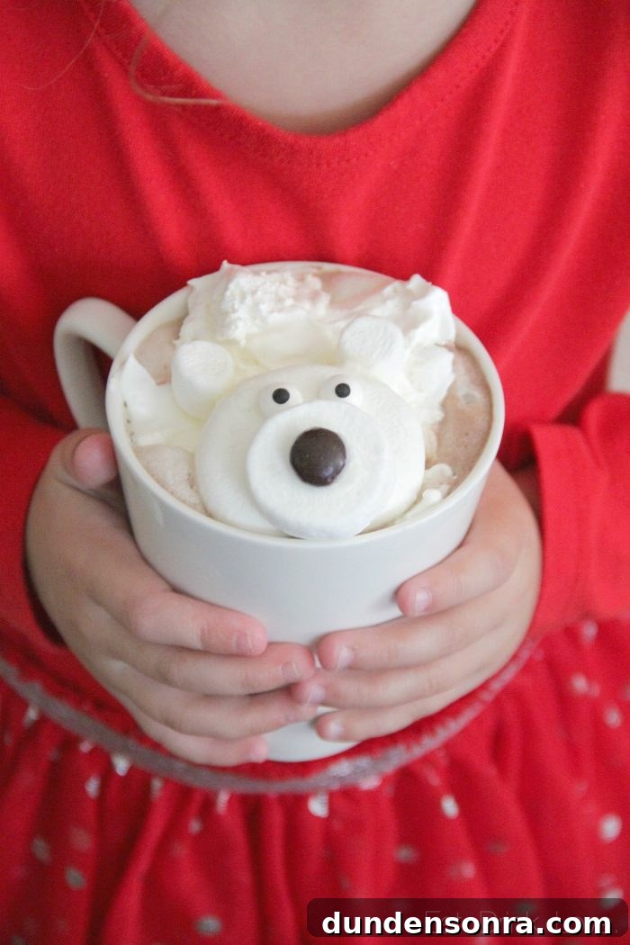 Polar Bear Party Child holding a mug of hot chocolate with marshmallows in the shape of a polar bear.