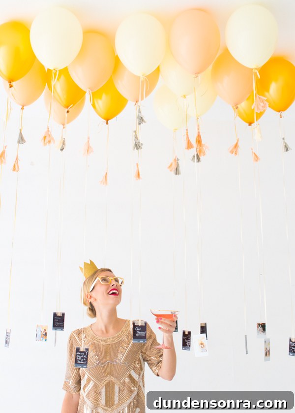 New Years Photo Party Woman looking up at golden balloons with photos tied to them at the bottom.