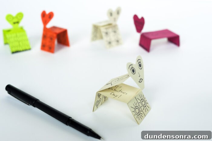 Printable and foldable valentine creatures next to a pen.