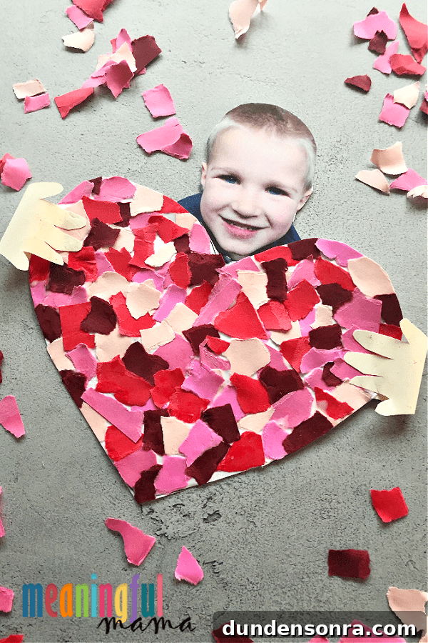 Child's photo with a heart made out of torn up paper.
