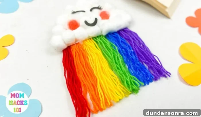 Rainbow Paper Plate Craft Cloud made out of cotton balls with strings coming out of the bottom in rainbow colors.