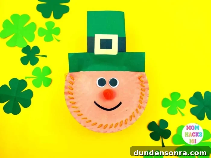Paper Plate Leprechaun Craft Paper plates sewn together to make a leprechaun face with a green hat.