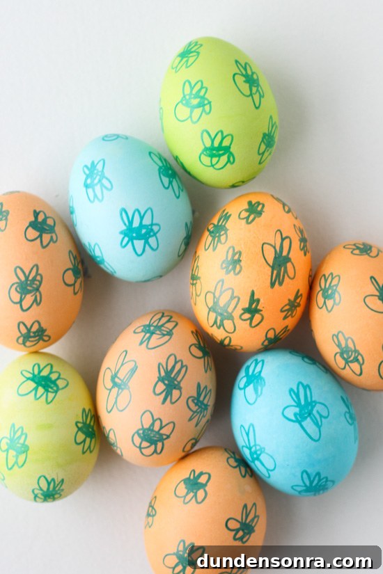 Pastel colored eggs with doodles drawn on them. 