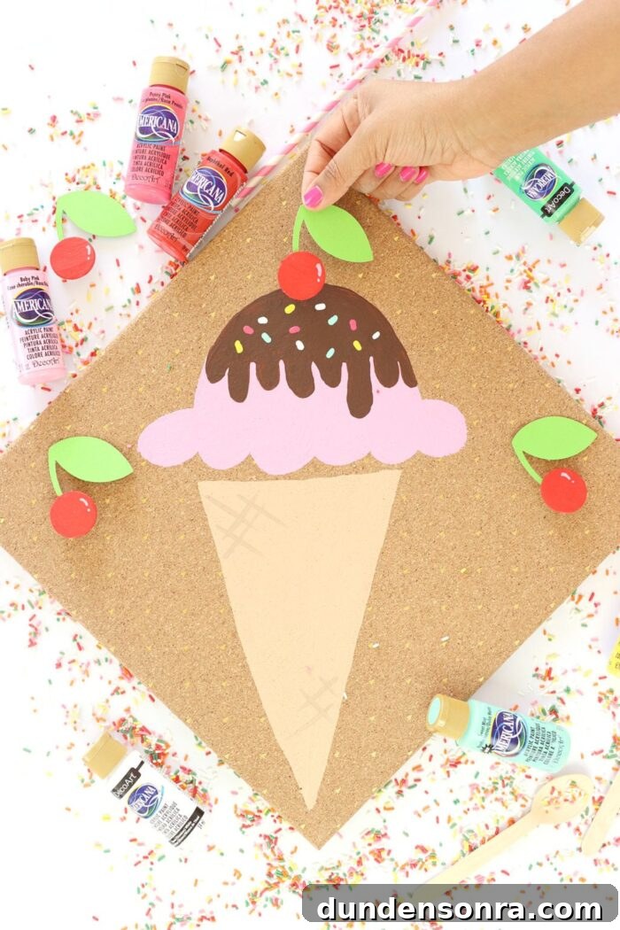 Ice Cream craft with a hand placing the cherry on top. 