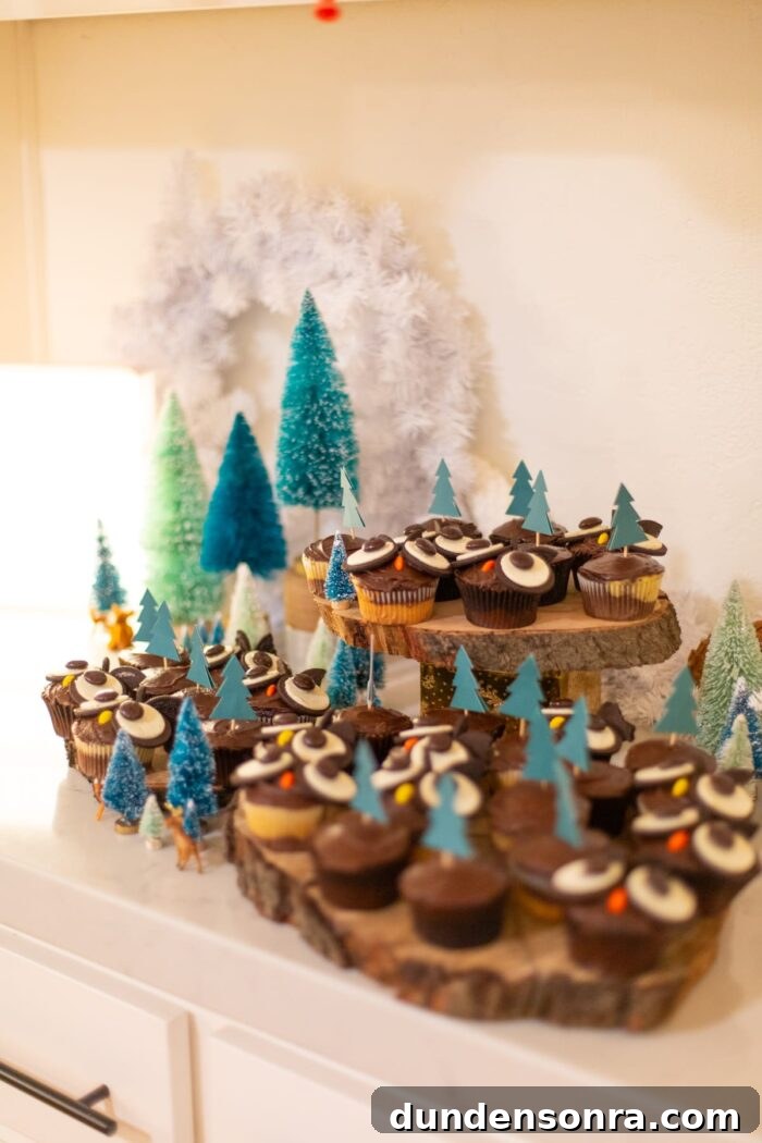 Table set with owl cupcakes and mini trees. 