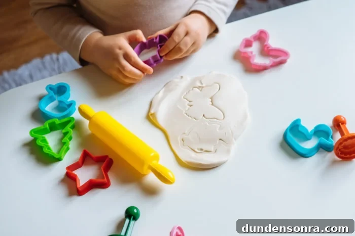Playdough rolled out next to cookie cutouts. 