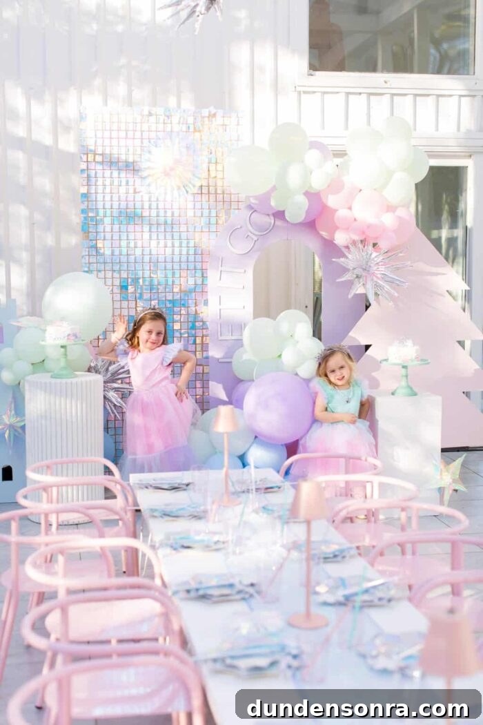 Frozen themed party with a dinner table and two kids posing. 