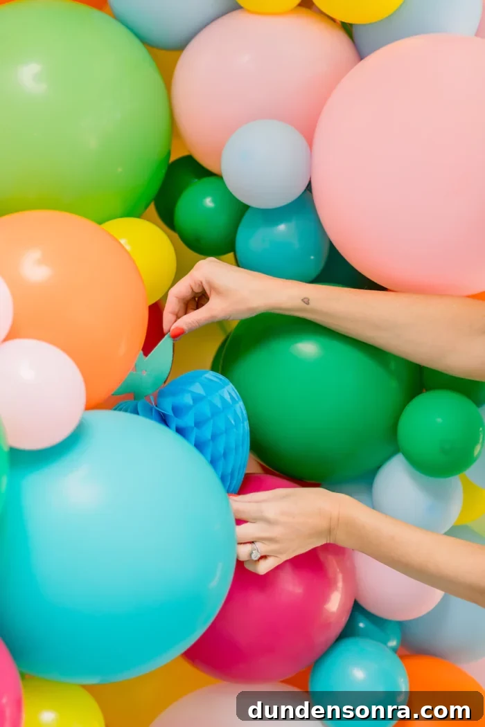 Balloons on a wall with hands adjusting. 