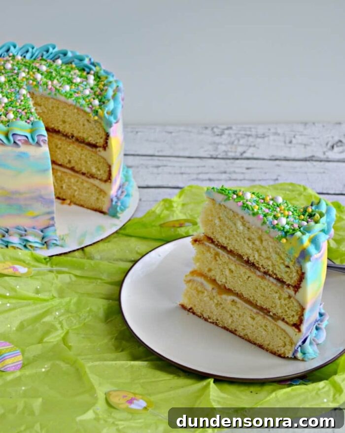 Watercolor Party Watercolor triple layer cake with a slice on a plate.