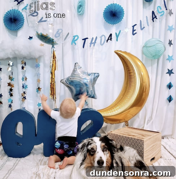 First Trip Around the Sun Birthday Party Baby grabbing a star shaped balloon that is surrounded by moon and star decorations.