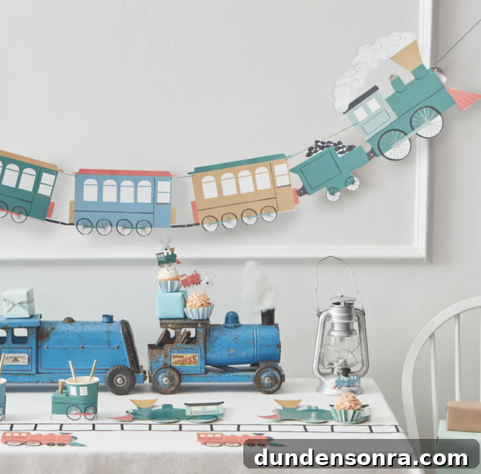 All Aboard Birthday Party Train garland hanging on the wall with a table with train decorations on it.