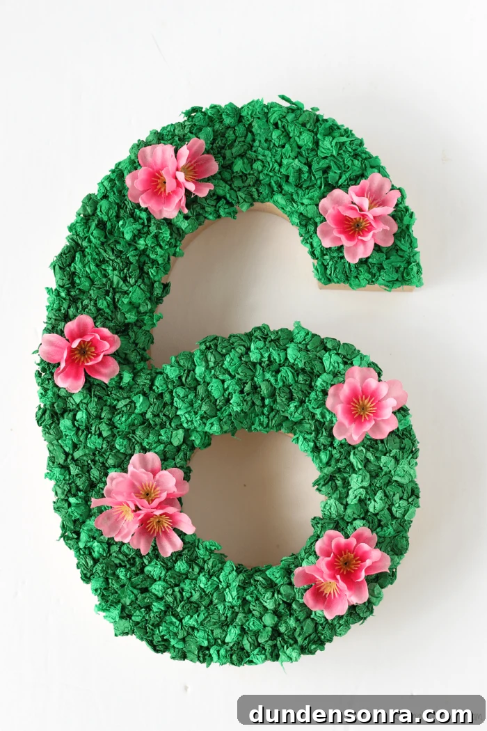 Moana Party Decoration Number 6 decorated with green tissue paper and pink flowers.