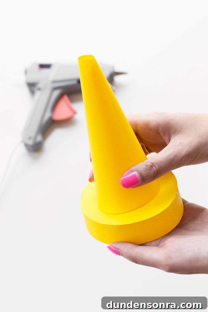 Someone holding a mini yellow cone.