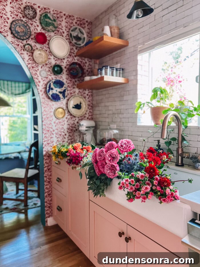 kitchen with flowers in sink and pink cabinets