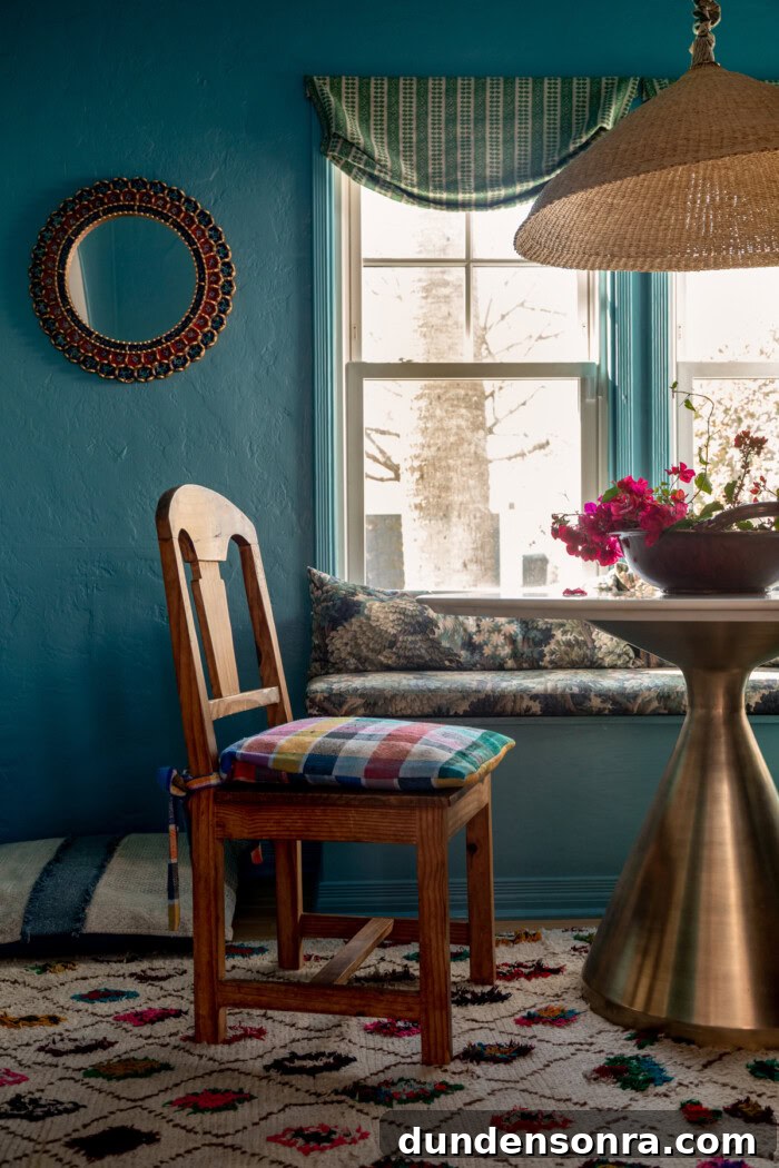 Wood dining chair in blue dining room with round mirror